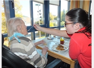 Unsere Auszubildende Jessica hilft einer Seniorin beim Mittagessen. Jessica will Altenpflegerin werden