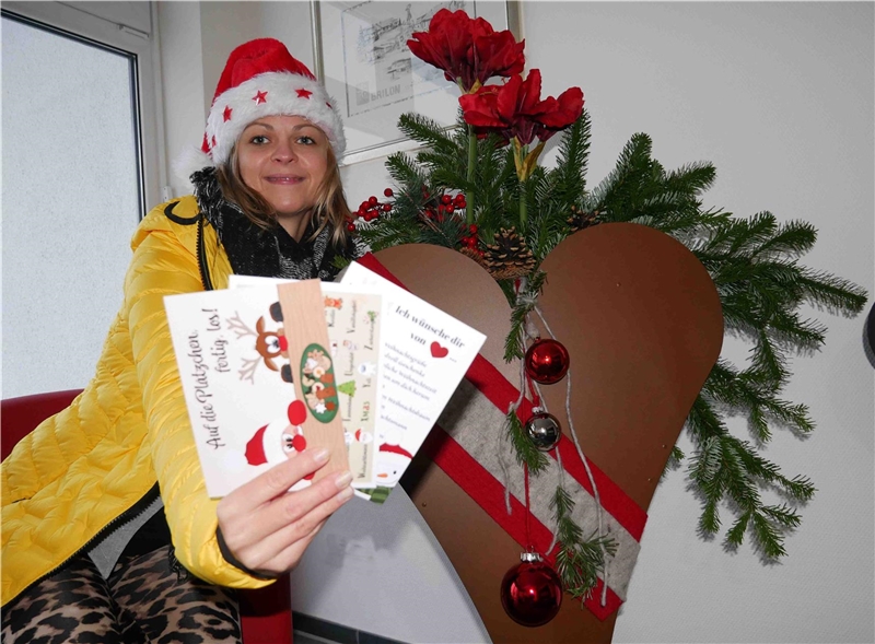 Auf den Bild werden drei Weihnachtskarten von einer Frau präsentiert.