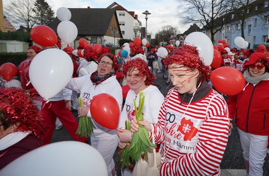 Rot-weiß gekleidete Frauen mit roten Perücken, Luftballons und Tulpen (WA Szkudlarek)