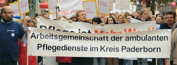 Einige Demonstranten halten ein großes Banner mit der Aufschrift "Arbeitsgemeinschaft der ambulanten Pflegedienste im Kreis Paderborn" hoch (Caritasverband Paderborn, Karl-Martin Flüter)
