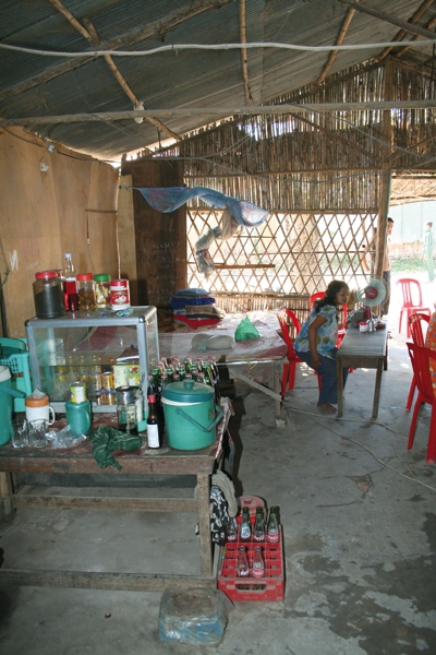 Sokhas Café in der Innenansicht. Auf der linken Seite befindet sich die Theke, rechts sitzt eine Frau an einem der Tische des Cafés. (Markus Lahrmann)