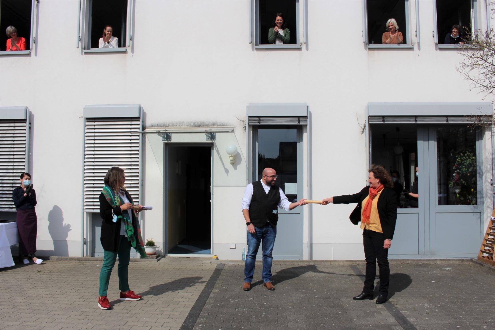 Personen stehen vor einem Gebäude. (Caritasverband Darmstadt e. V.)