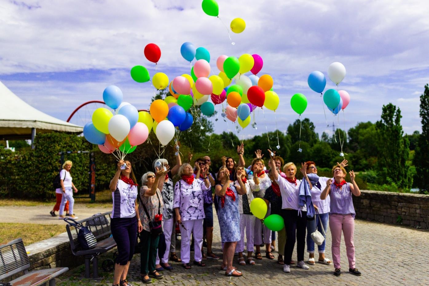 Heliumballons und Menschengruppe in einem Park 