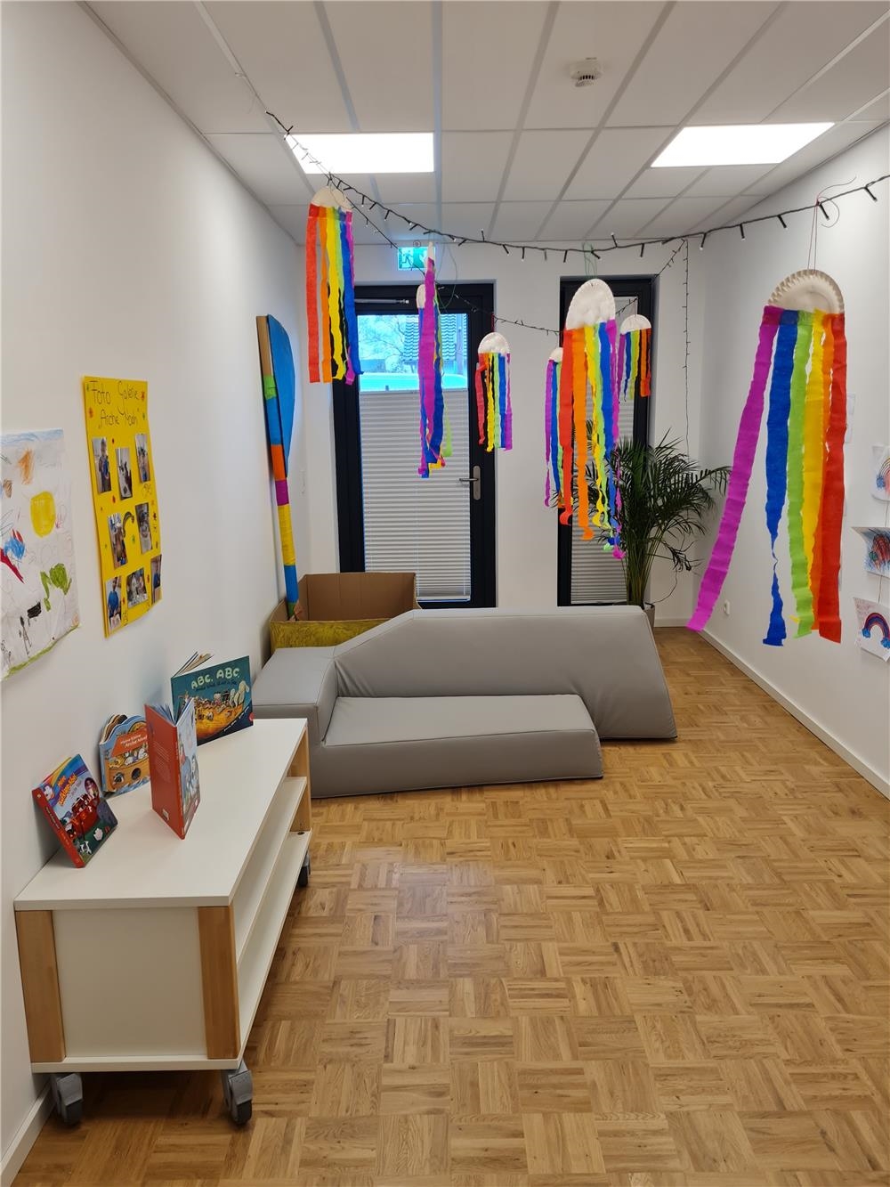 Ein Zimmer ist mit bunten Regenbogen aus Krepppaier geschmückt. 