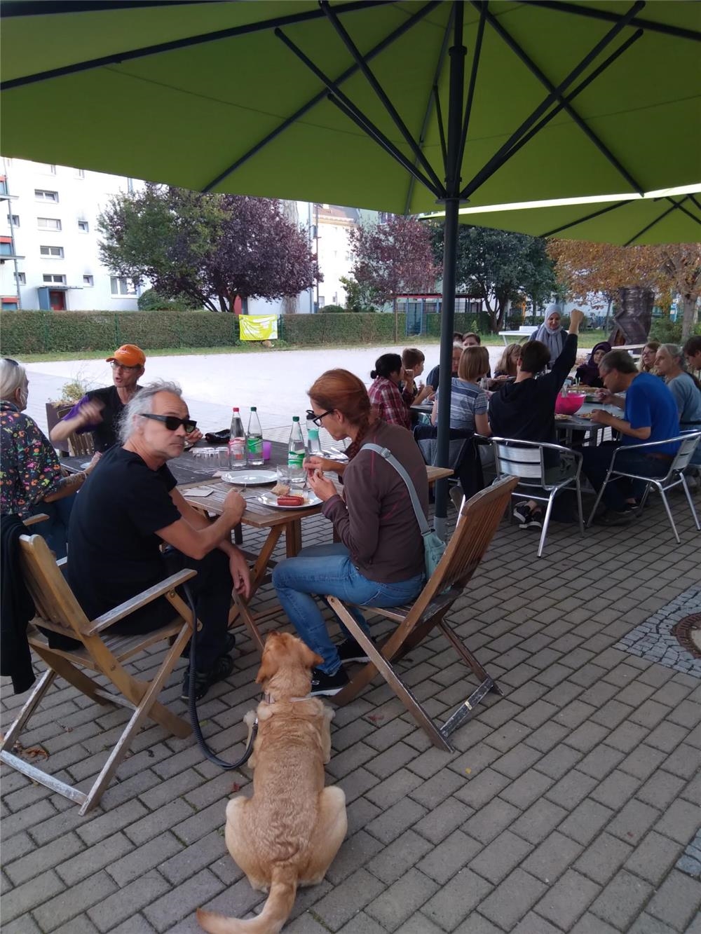 An zwei großen Tischen sitzen etwa 20 Personen und essen gemeinsam. (Daniel Naumann)