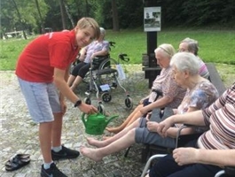 Ein junger Schülerpraktikant verabreicht an Senioren mit einer Gießkanne einen Kneipp-Knieguss / Foto: Kayko