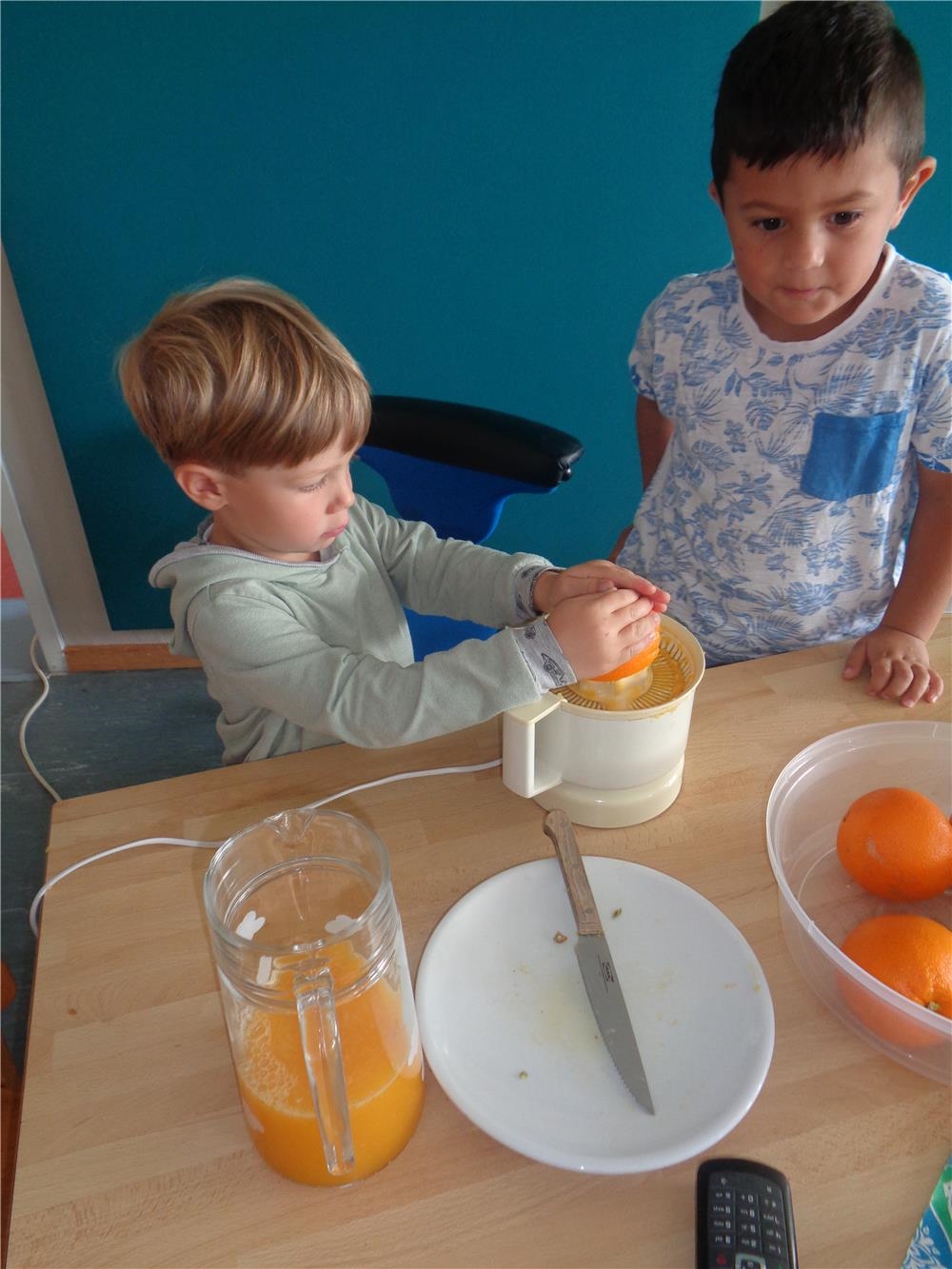 Zwei Kinder pressen Orangen aus 