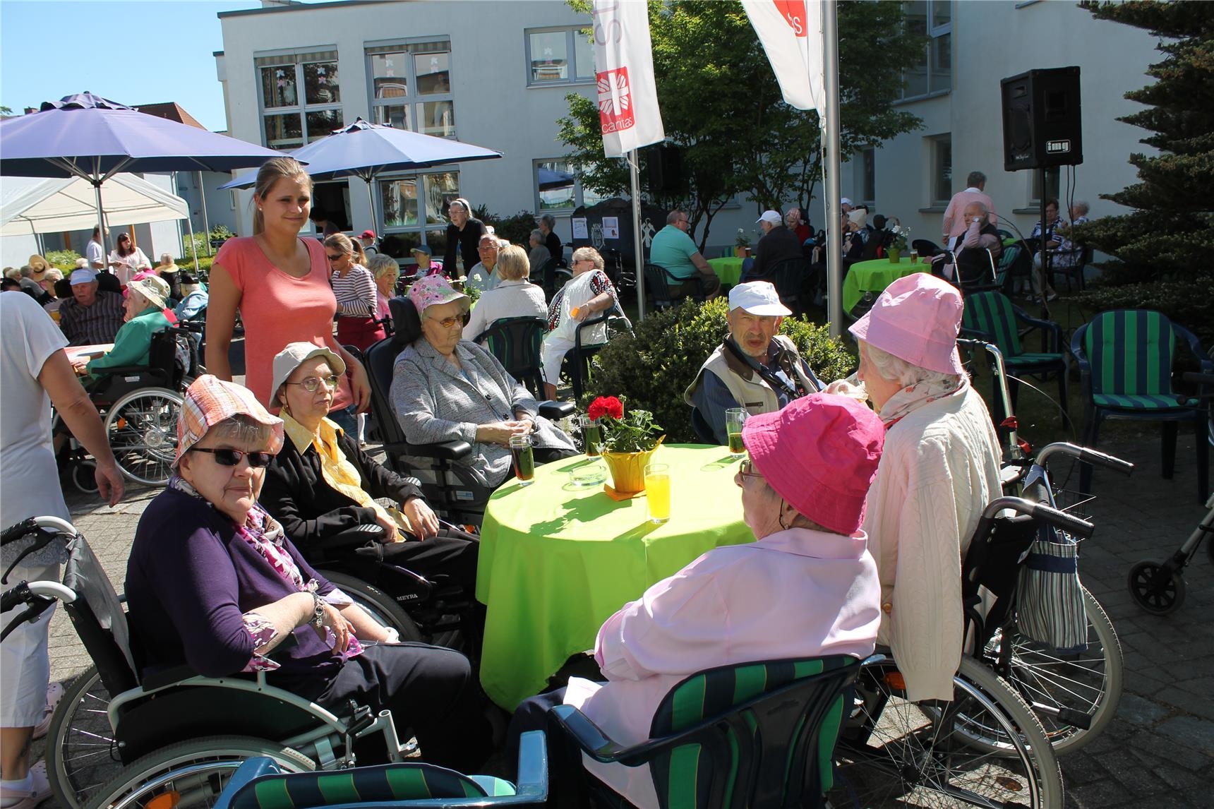 Senioren sitzen in der Sonne am Tisch mit Getränken (St. Vinzenz-Vorsterhausen)