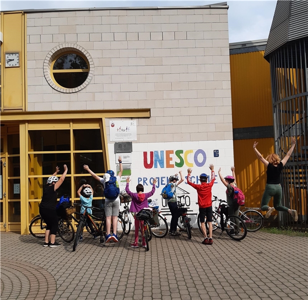 Kinder mit Fahrrad vor der UNESCO Schule