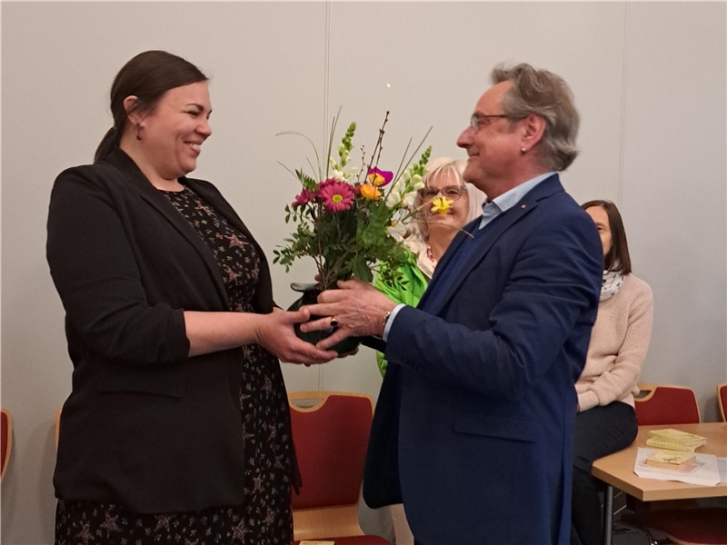 Reinhard Kühn überreicht Dr. Marie Kajewski einen Blumenstrauß