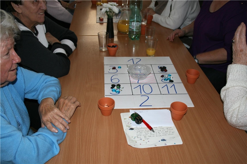 Senioren spielen am Tisch ein Spiel