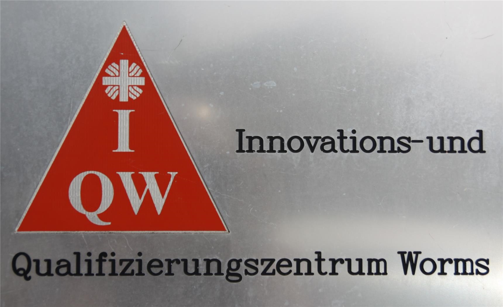 Schild am Eingang zum Innovations- und Qualifizierungszentrum Worms (IQW) (© Caritasverband Worms e. V.)