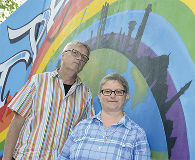 Klaus Peter Bongardt und Sr. Martina stehen vor einer Graffitiwand mit einem Regenbogen und einer Weltkugel auf der die Skyline von Duisburg steht. (Christoph Grätz)