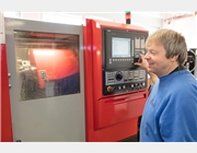 Ein Mitarbeiter bedient eine CNC-Drehmaschine. 