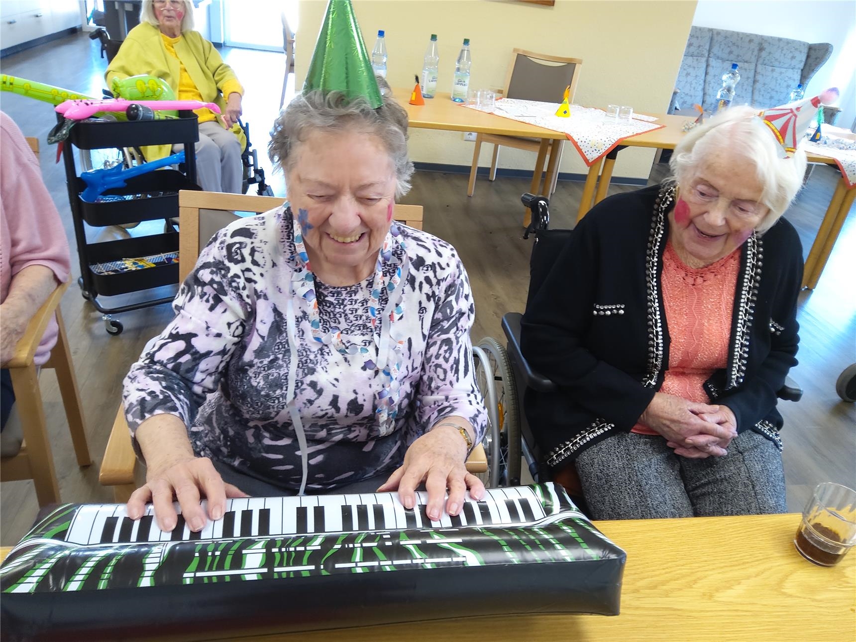 zwei Bewohnerinnen haben Spaß mit einer Klaviertastatur, die aber nur aufgeblasen und nicht echt ist     (Caritas-Altenzentrum St. Martin)
