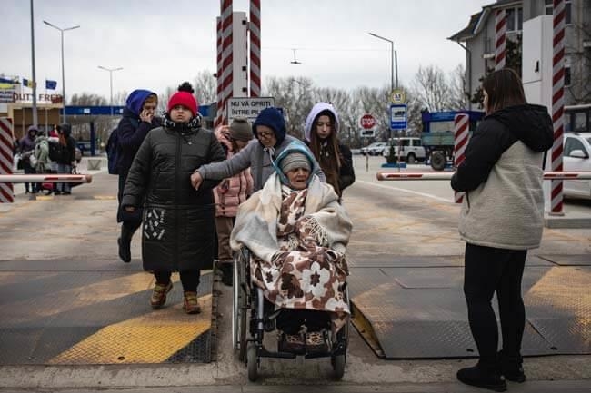 Frau im Rollstuhl wird in Sicherheit gebracht (Foto: Marijn Fidder /Caritas international)