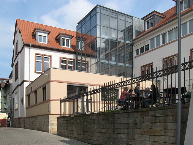 Außenansicht eines Gebäudes mit Gartenlokal (Caritasverband Darmstadt e. V.)