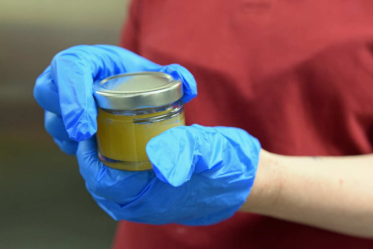 Eine Mitarbeiterin der CBW schraubt in einer Küche ein kleines Gläschen mit Honig zu. (Foto: Thomas Hohenschue)