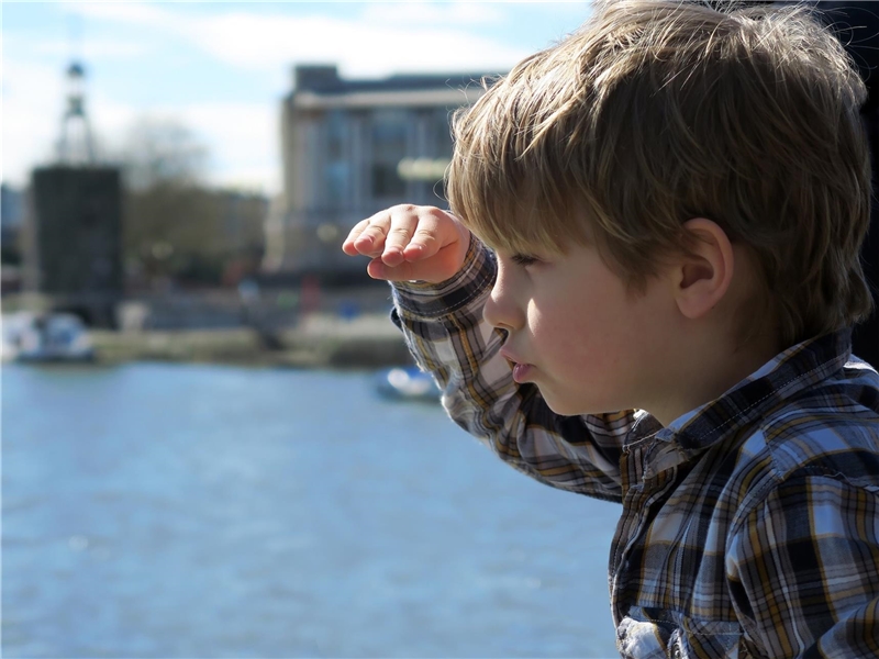 Ein Junge schaut suchend über einen See.