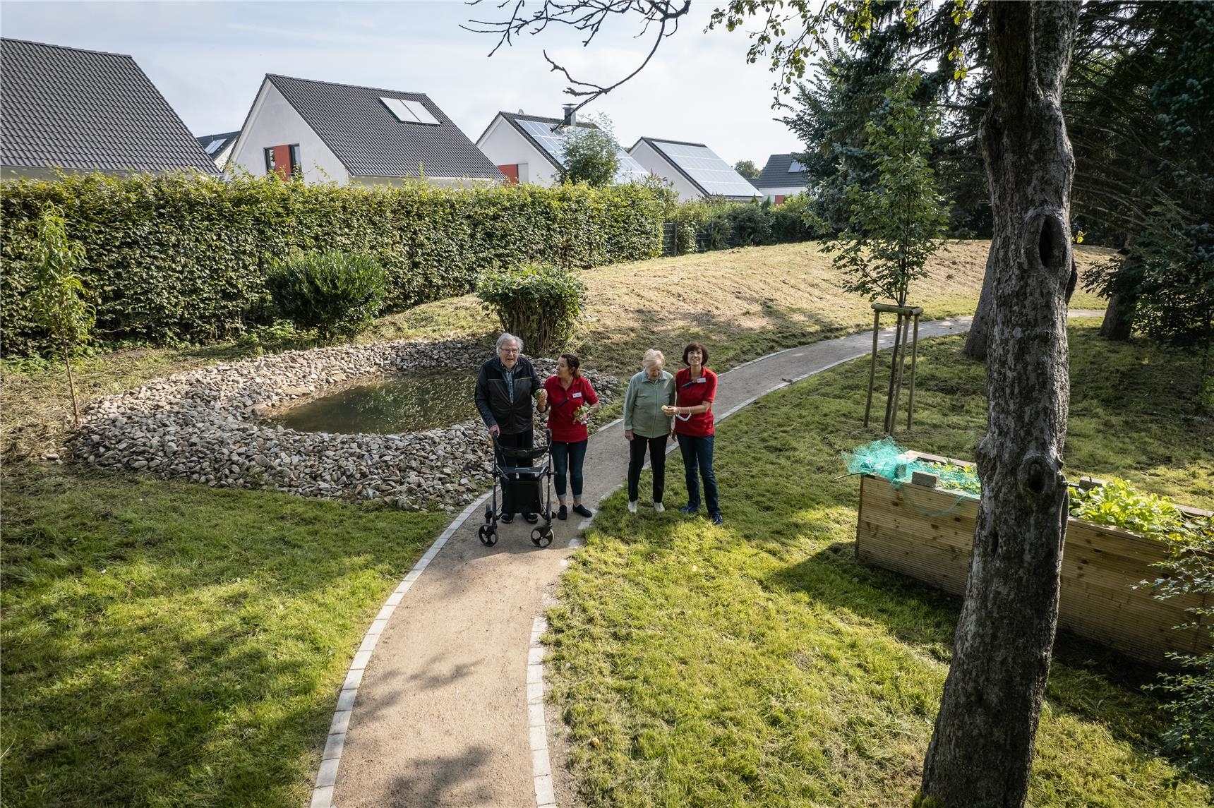 Menschen gehen durch eine Grünanlage spazieren 