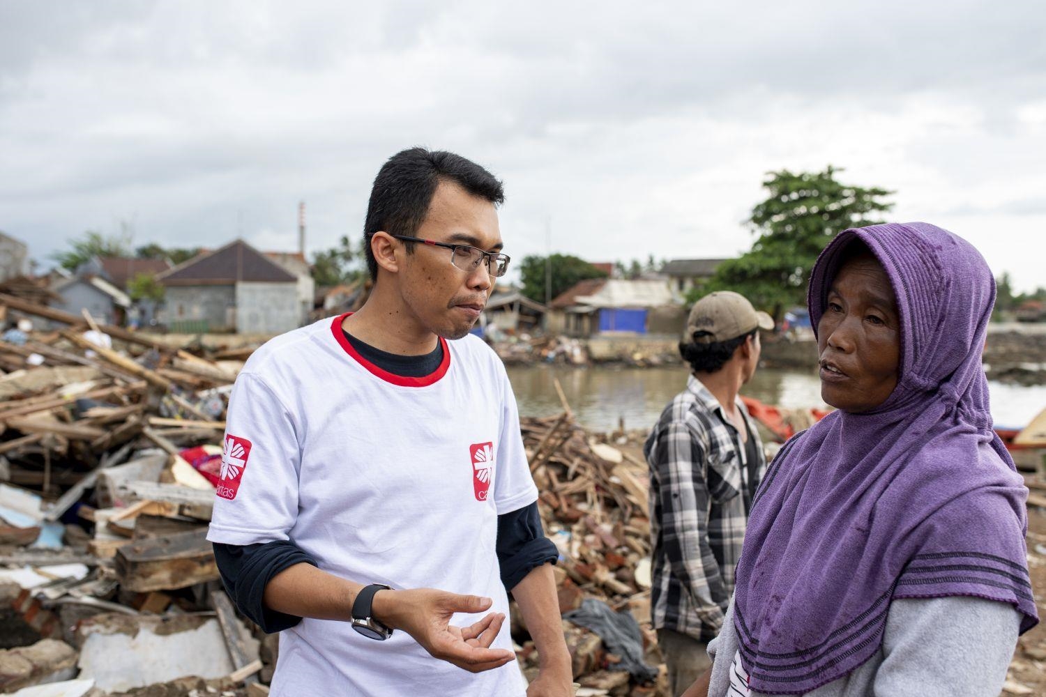 Helfer der Caritas im Gespräch mit indonesischem Flutopfer (Bente Stachowske / Caritas international)