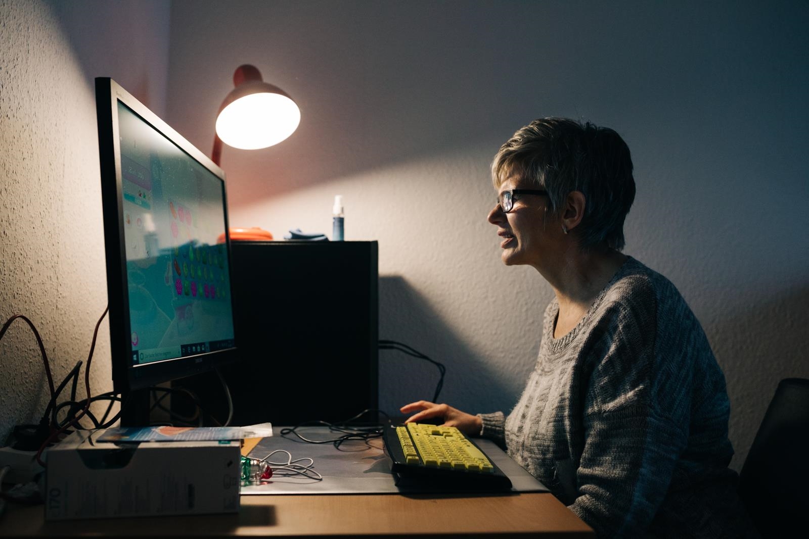 Frau vor einem Computerbildschirm mit Tastatur