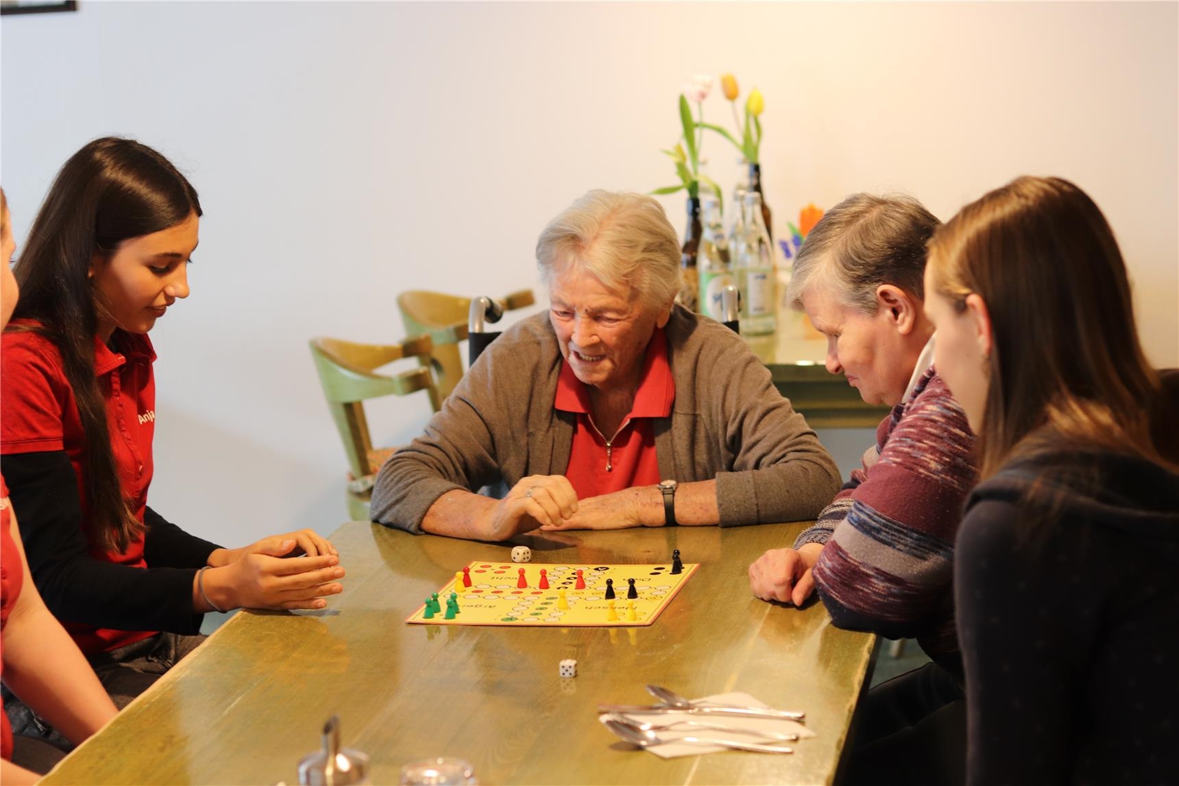 Bewohnerin Rita Kellenter freut sich über das gemeinsame Brettspiel mit den Jugendlichen 
