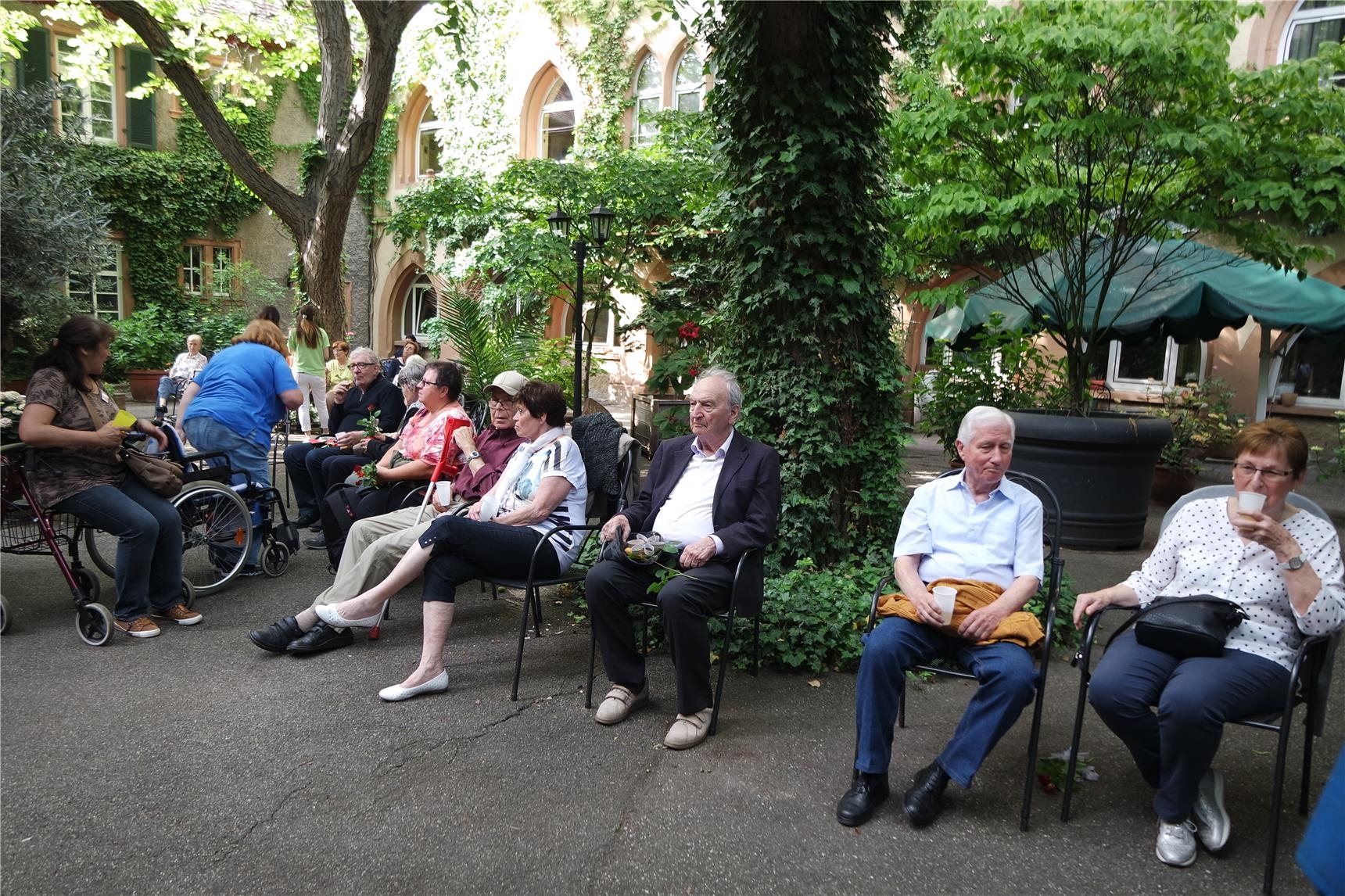 Besucher_innen des Gottesdienstes sitzen im Innenhof der St. Martinskirche (Edelgard Gardt)