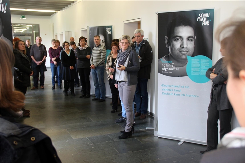 Eine Frau steht vor der Ausstellung und redet.