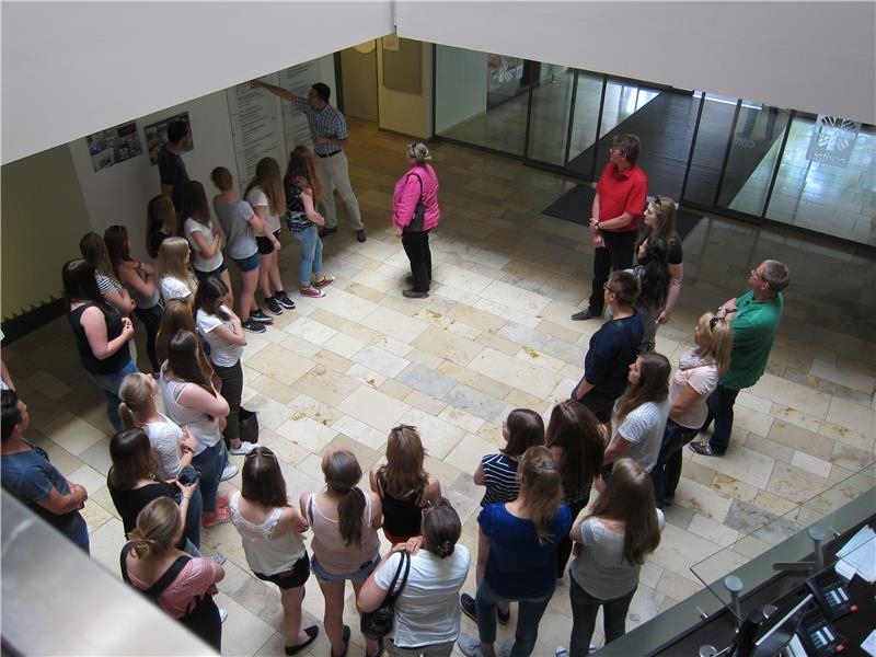 Jugendliche stehen im Kreis und hören dem Vortragenden aufmerksam zu. (youngcaritas Deutschland)