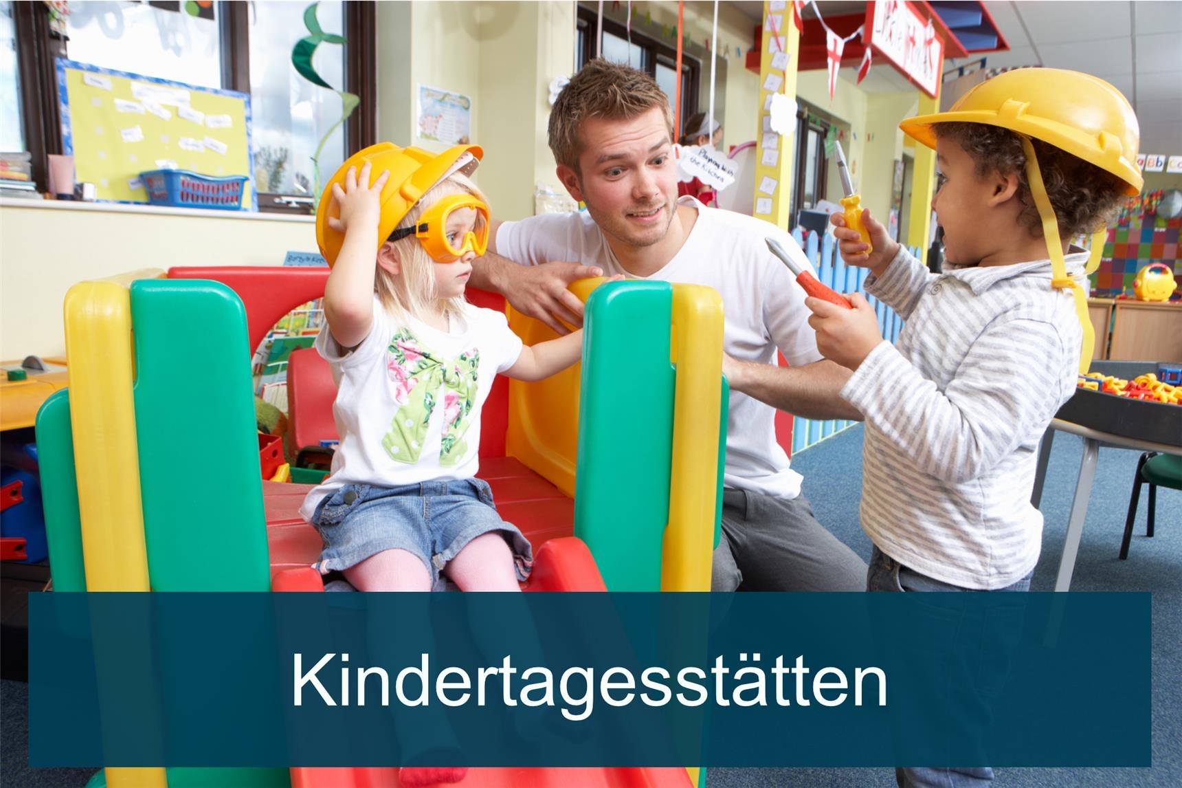 Kinder sitzen am Tisch uns spielen mit Bauklötzen. Sie drehen sich zur Kamera und machen Faxen.