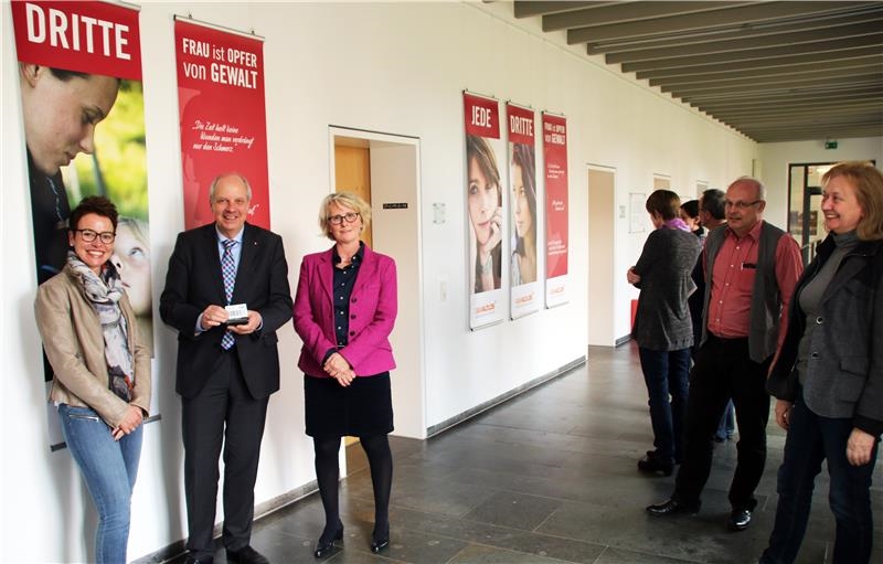 Acht Personen stehen vor den Ausstellungsstücken und unterhalten sich darüber