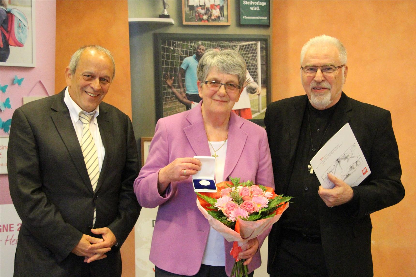 Beatrix Schlausch wird die Dankmedaille von Dr. Hejo Manderscheid und Monsignore Michael Metzler überreicht (Petra M. Schubert)