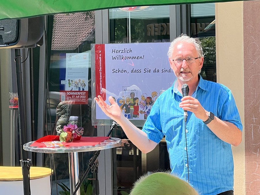 Ein Mann an einem Mikrofon hält eine Rede (Caritasverband Darmstadt e. V. / Jens Berger)