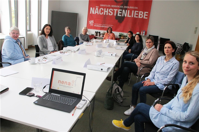 Auf dem Foto sind zehn Frauen zu sehen, die in einem Stuhlkreis um einen großen Tisch sitzen.