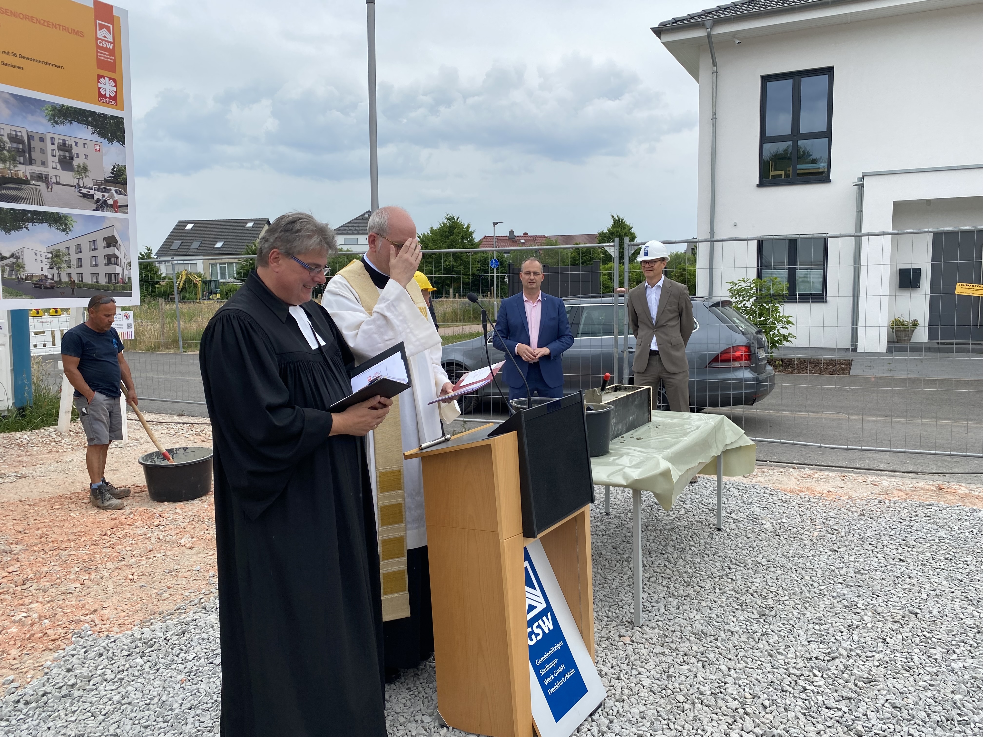 Zwei Pfarrer auf einer Baustelle (Caritasverband Darmstadt e. V.)