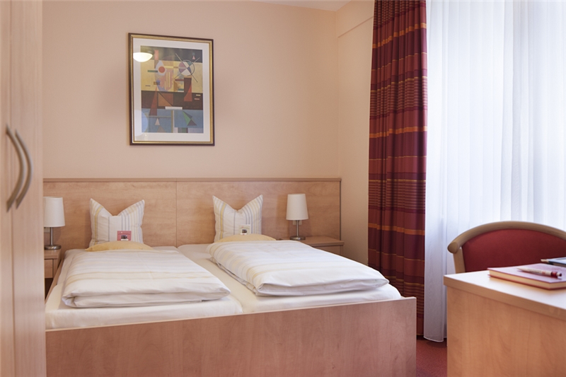 Ein Doppelzimmer des Hotels mit Willkommenskärtchen auf den Kissen 