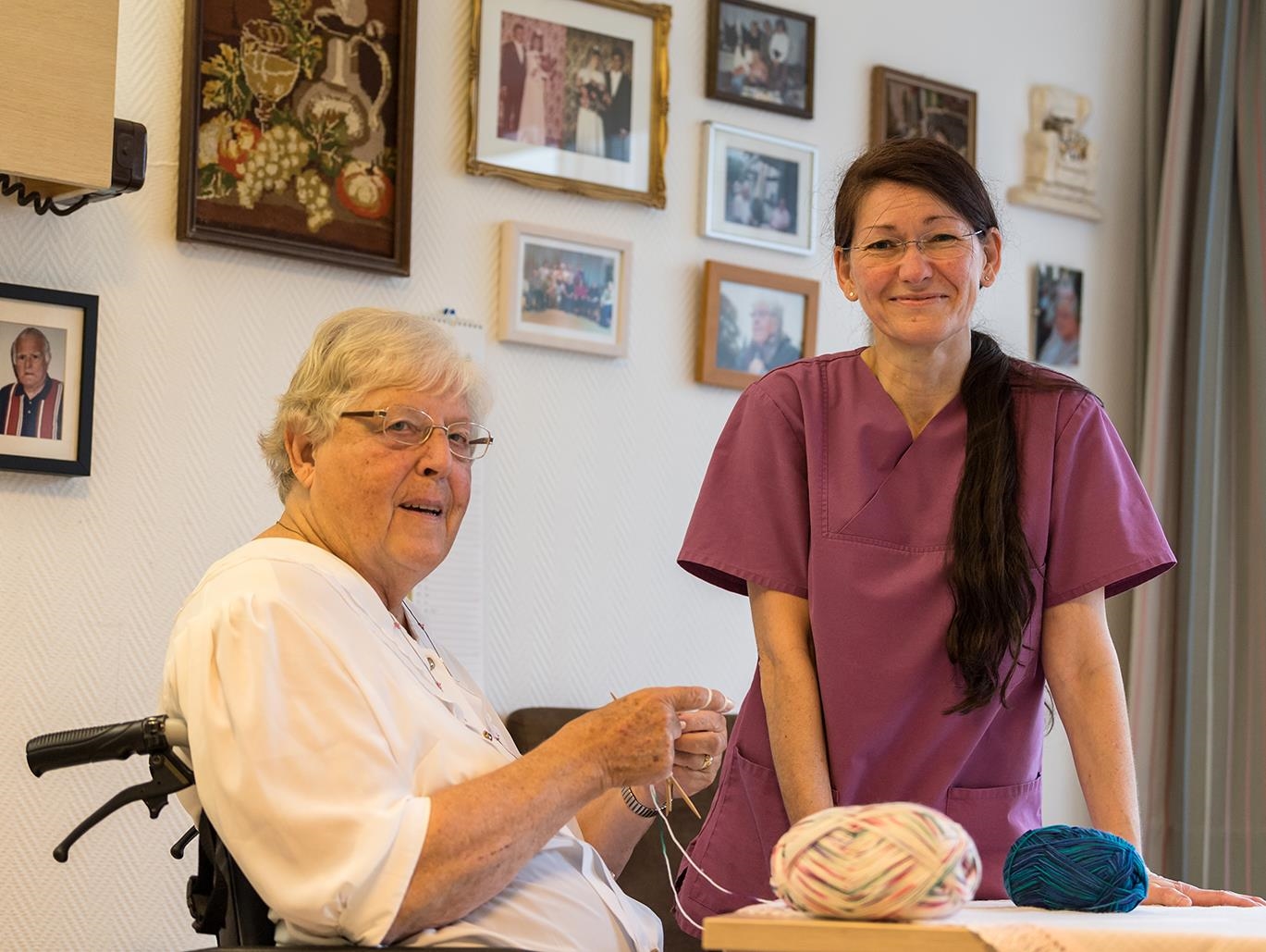 Eine Pflegerin mit einer strickenden Seniorin. (Deutscher Caritasverband e.V./Pedro Citoler)