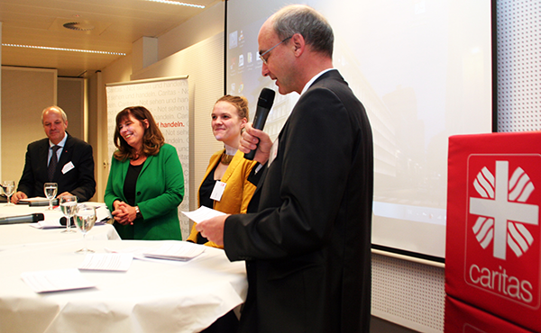 Heinz-Josef Kessmann, Jutta Steinruck und Terry Reintke stehen auf dem Podium neben einigen Tischen. Markus Lahrmann steht mit einem Mikrofon daneben und führt die Moderation. (Harald Westbeld)