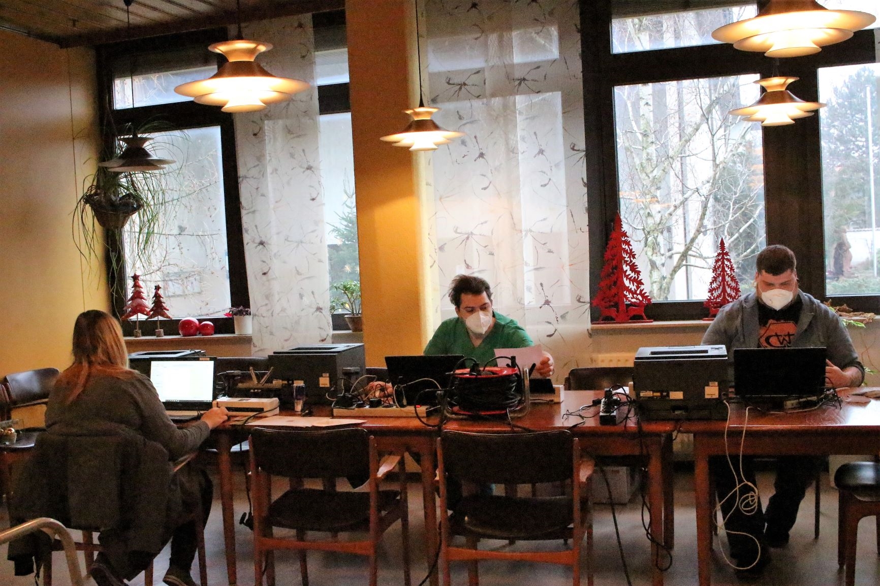 Drei Personen sitzen an einem Tisch, Computer stehen vor ihnen. (Caritasverband Darmstadt e. V.)