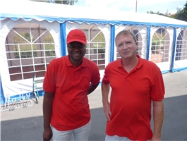 Zwei Männer im roten Poloshirt stehen vor einem Partyzelt / Foto: Schedlbauer