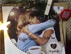 Kaffeetüte und Bild von zwei sich umarmenden Frauen / KiChAll