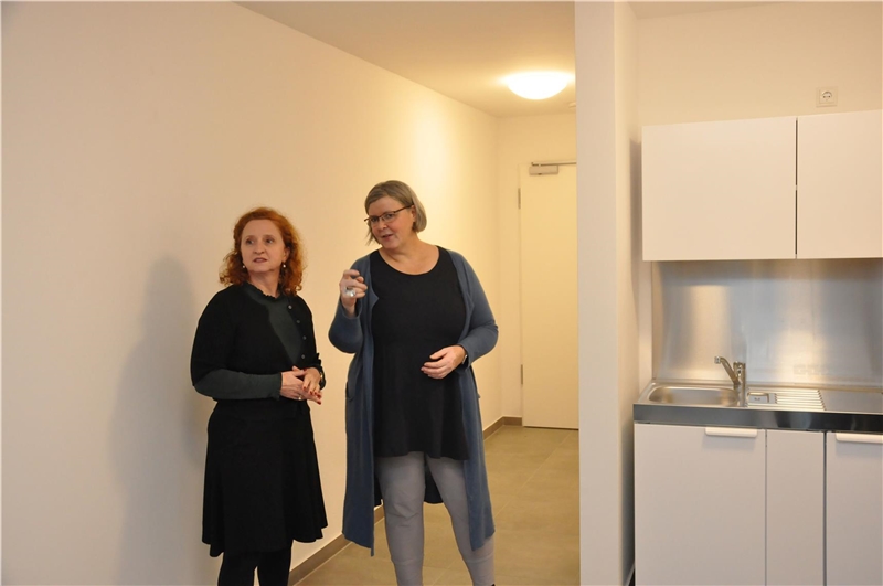Elke Voitl und Gaby Hagmans in einem Apartment mit kleiner Küchenzeile