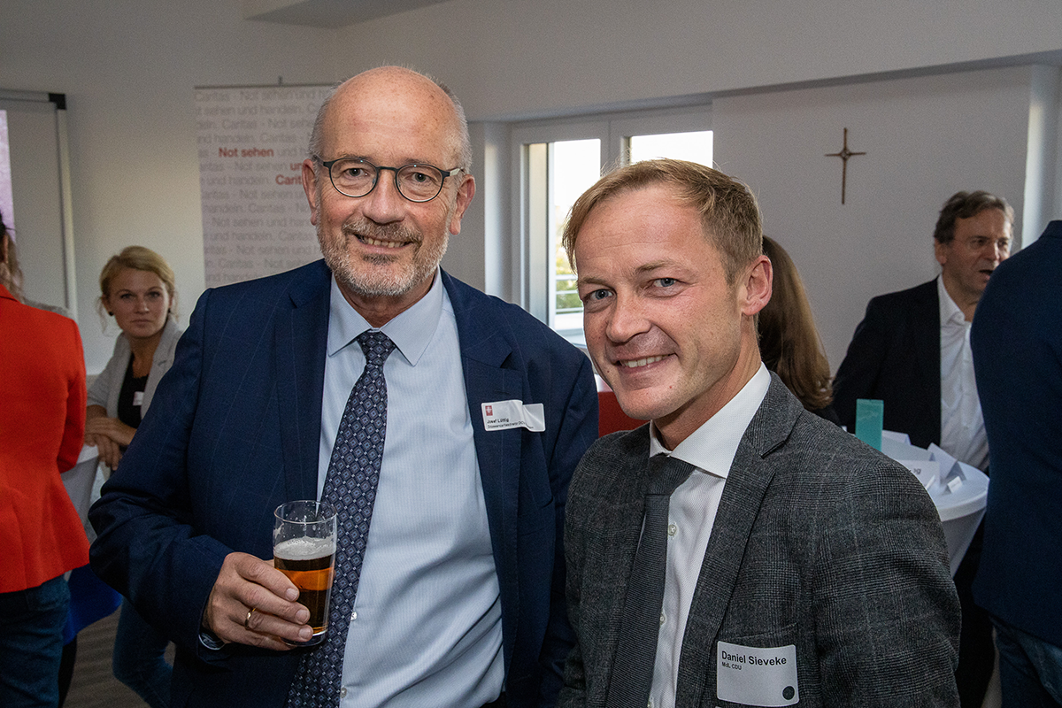 Josef Lüttig und Daniel Sieveke MdL stehen auf dem Parlamentarischen Abend der Caritas in NRW am 19.09.2019 in Düsseldorf zusammen und blicken in die Kamera  (Achim Pohl)
