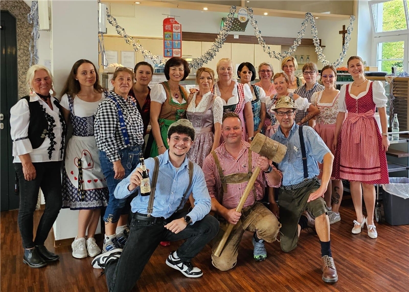 Viele Menschen in bayerischer Tracht stehen zu einem Gruppenbild zusammen.