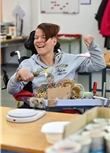 Eine behinderte Frau im Rollstuhl hat sichtlich Freude / KNA - Deutscher Caritasverband e. V.