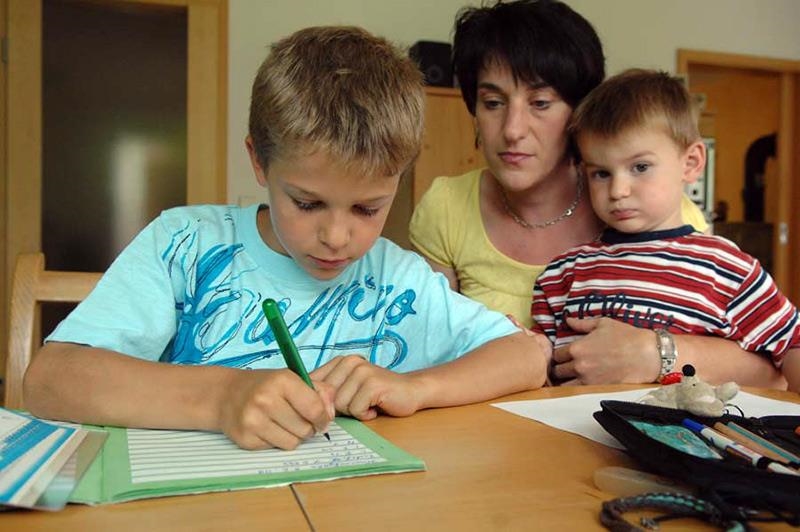 Mutter hilft ihrem Sohn bei den Hausaufgaben