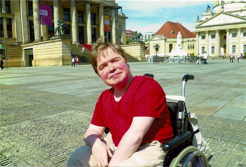 Eine Frau in Rollstuhl, die sich auf dem Gendarmenmarkt in Berlin befindet (Caritas)