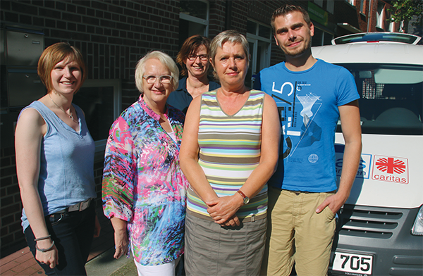 Gruppenfoto des SPFH-Teams vom Caritasverband Ibbenbüren, bestehend aus vier Frauen und einem Mann, dass neben ihrem weißen Dienstwagen steht (Harald Westbeld)