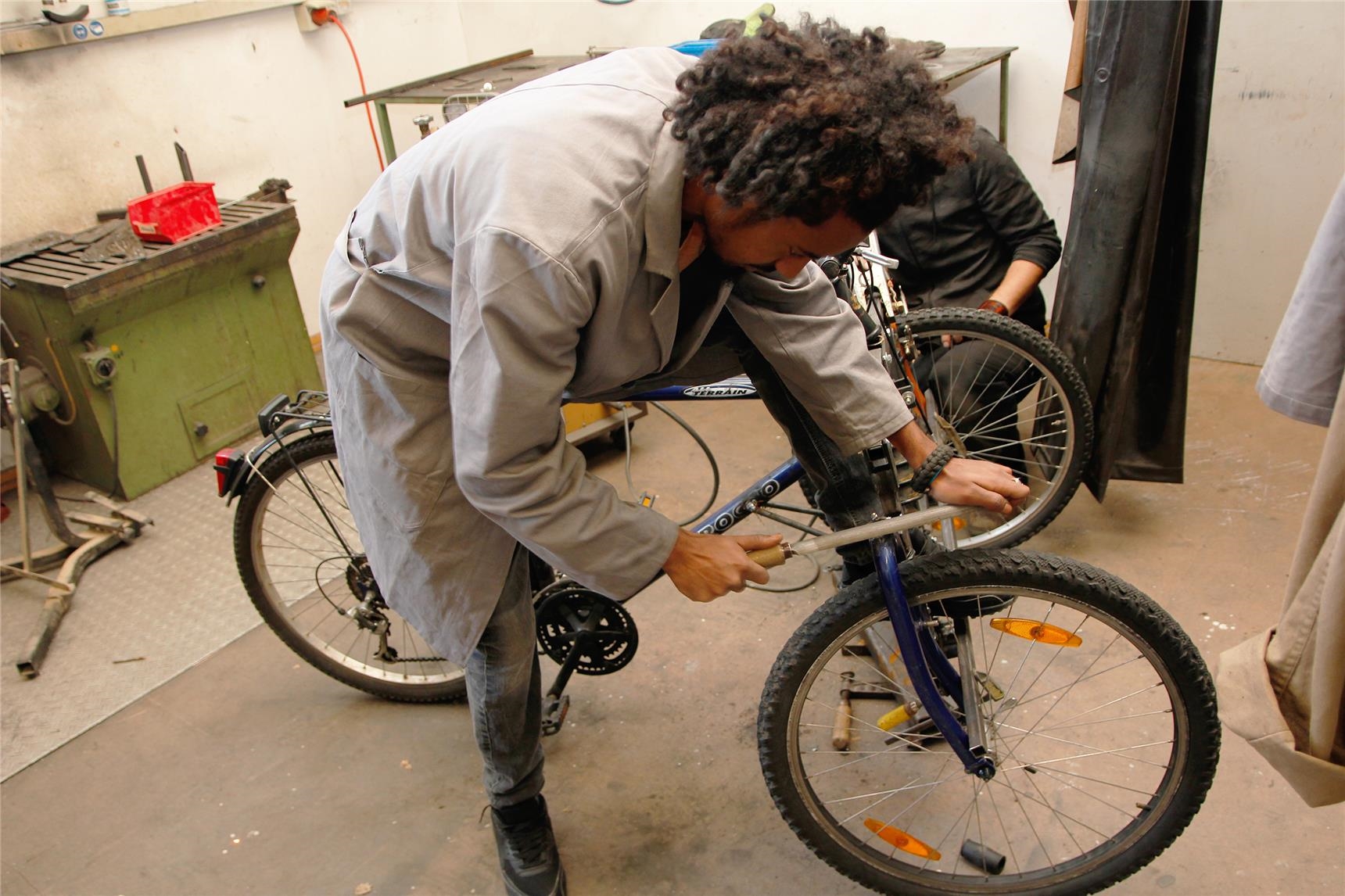 Jamal Abdu schlieft mit der Eisenfeile die rauen und kantigen Stellen dort ab, wo die Fahrradgabel zuvor abgesägt worden war. (Bernhard Gattner)